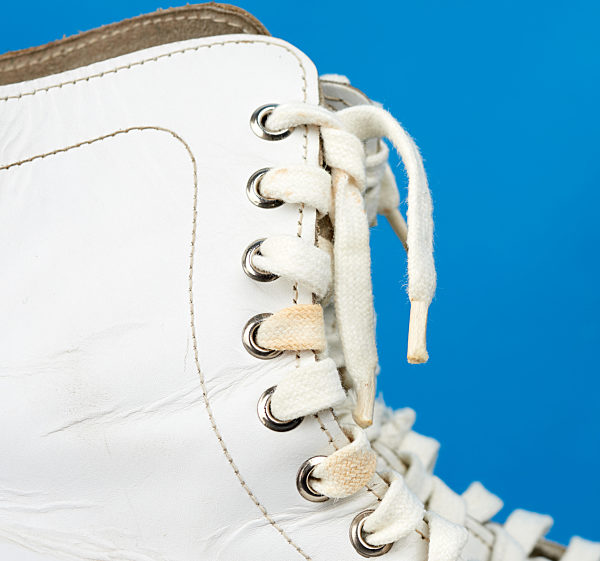 fragment of white leather figure skates with white textile laces