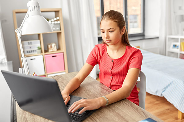 student girl with laptop computer learning at home