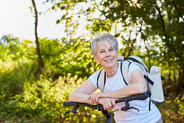 Vitale Senior Frau mit Fahrrad oder Tretroller