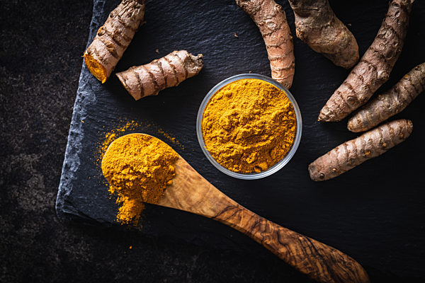 Indian turmeric powder and root. Turmeric spice. Ground turmeric.