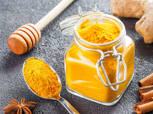 turmeric powder in glass jar and spoon