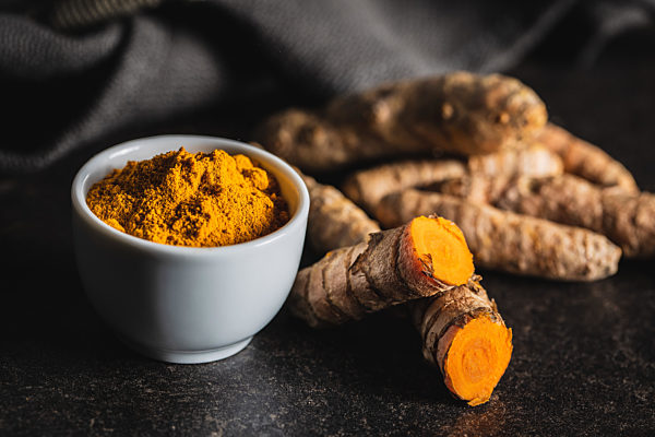 Indian turmeric powder and root. Turmeric spice. Ground turmeric.