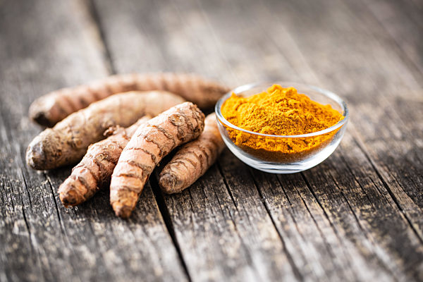 Indian turmeric powder and root. Turmeric spice. Ground turmeric.