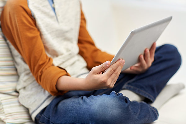 close up of boy with tablet pc computer at home