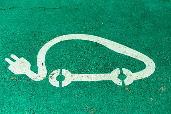 Car charging symbol painted on asphalt.