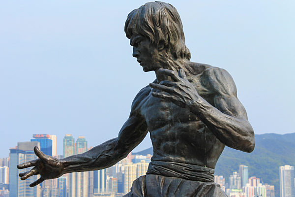 Detail view on Bruce Lee Monument on Avenue of Stars near the promenade. Skyline of Hongkong Island in background. Tsim Sha Tsui, Hong Kong, China.