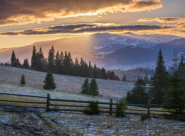 Picturesque sunset above late autumn mountain countryside.  Ukraine, Carpathian Mountains. Peaceful traveling, seasonal, nature and countryside beauty concept scene.