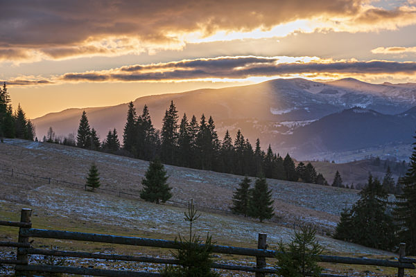 Picturesque sunset above late autumn mountain countryside.  Ukraine, Carpathian Mountains. Peaceful traveling, seasonal, nature and countryside beauty concept scene.