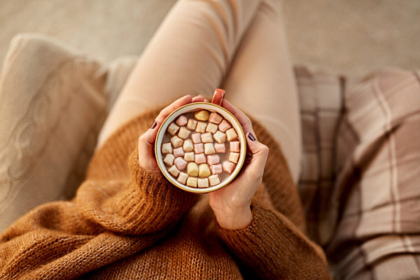 woman holding mug of hot chocolate and marshmallow
