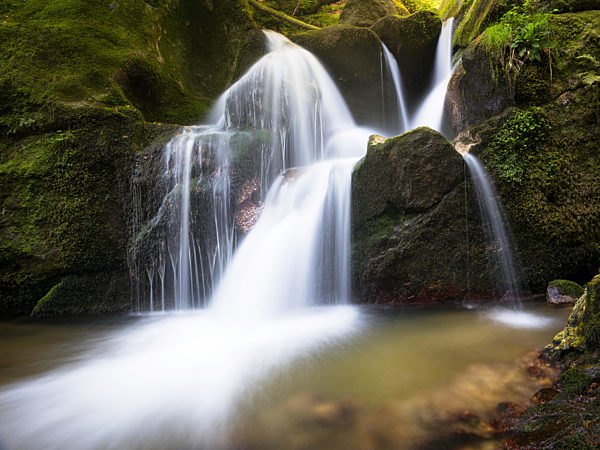 Long exposure waterfall over brown and green rocks at Bad Kreuzen Austria