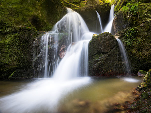Long exposure waterfall over brown and green rocks at Bad Kreuzen Austria