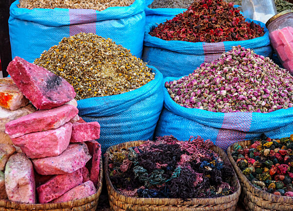 Piles of dried rose and other flowers used as natural fragrances displayed on souk - traditional street market in Morocco