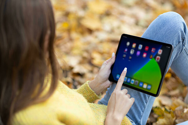Young woman model in autumn park with yellow foliage maple leaves. Fall season fashion.