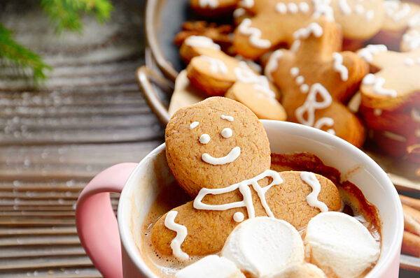 Pink mug with hot chocolate marshmallows and gingerbread man closeup