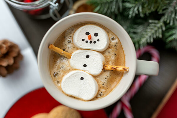 marshmallow snowman in cup of coffee on christmas
