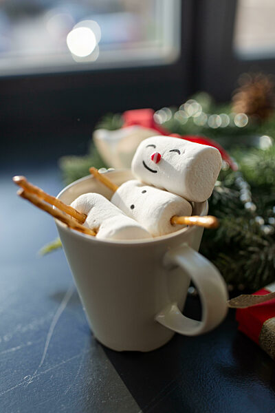 marshmallow snowman in cup of coffee on christmas