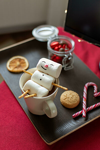 marshmallow snowman in cup of coffee on christmas