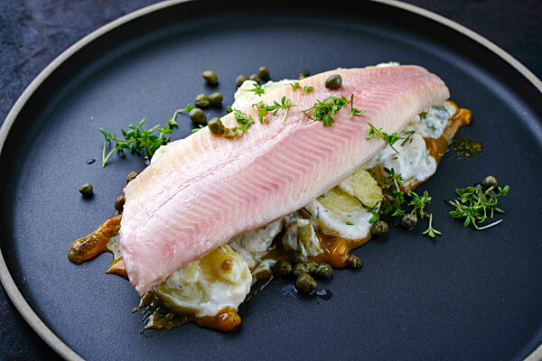 Modern style traditional smoked rainbow trout with boiled potato salad