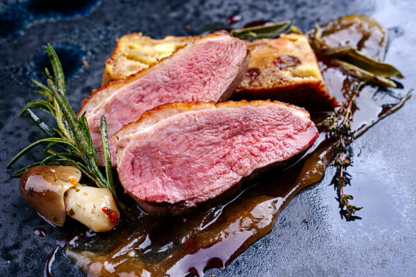 Barbecue gourmet duck breast filet with mushrooms and apricot pate served as close-up on a design plate