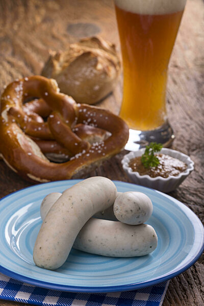 Bayerische Weißwürste mit Brezel auf Holz