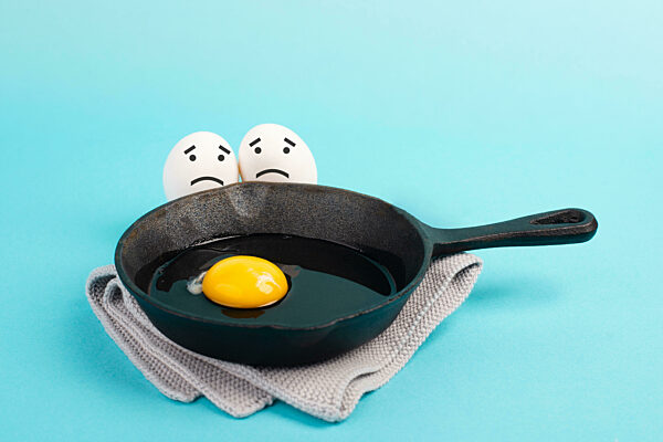 A fried egg in a pan, two friends look with sad faces at him, having a breakfast in the morning, fun