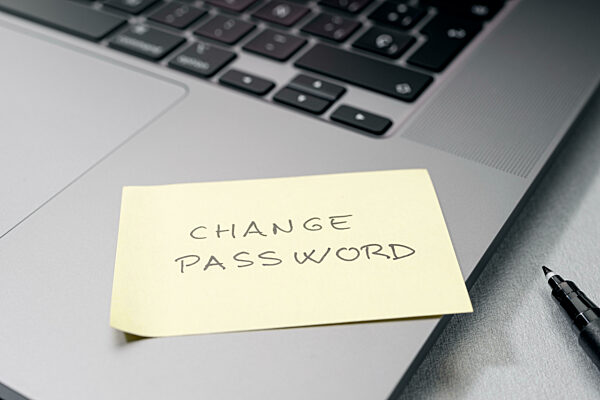Change password message on sticky note on laptop. Computer security management concept