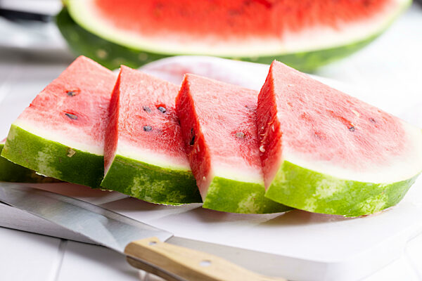 Slices of red watermelon on cutting board.