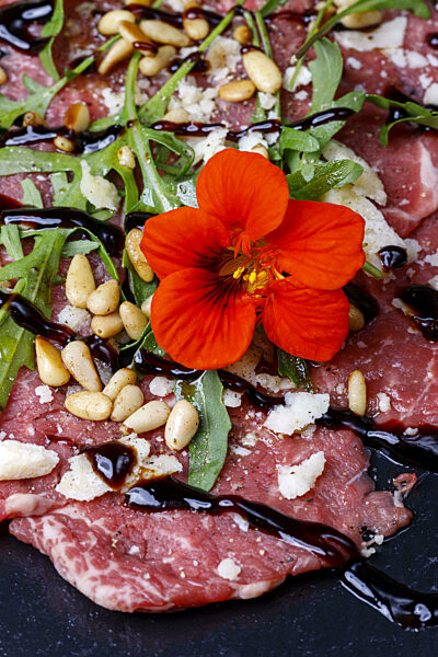 frisches Carpaccio mit Rucola auf Schiefer