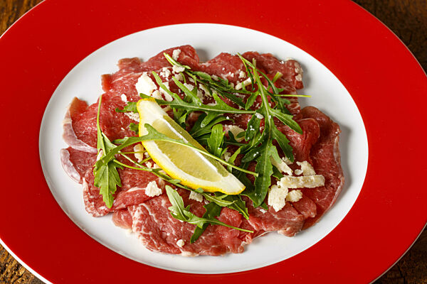 frisches Carpaccio mit Rucola auf dem Teller