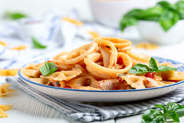 Pasta farfalle with squid in tomato sauce.