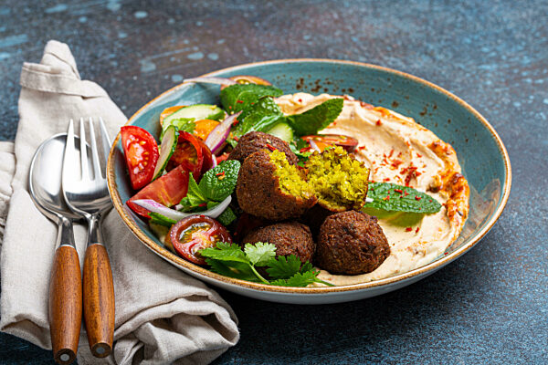 Close up of Middle Eastern Arab meal with fried falafel, hummus, vegetables salad