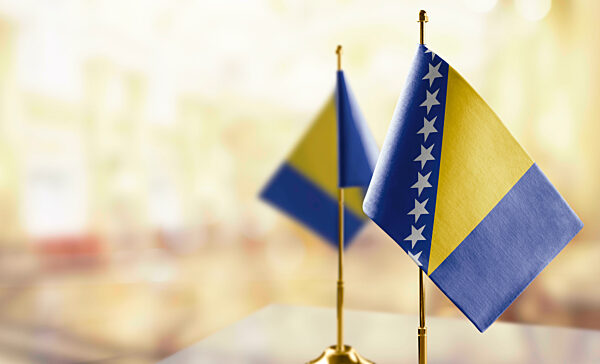 Small flags of the Bosnia and Herzegovina on an abstract blurry background