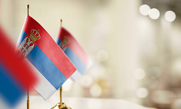 Small flags of the Serbia on an abstract blurry background