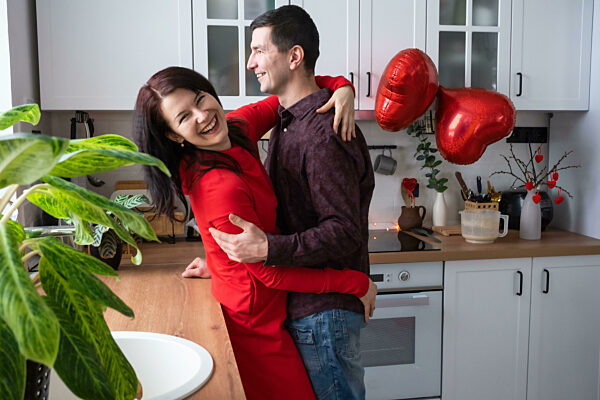 Man and woman in love date at home in kitchen happy hugs. Valentine's Day, happy couple, love story. Love nest, housing for young family