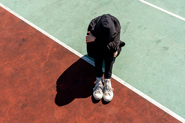 Depressed and hopeless teenage girl sitting alone