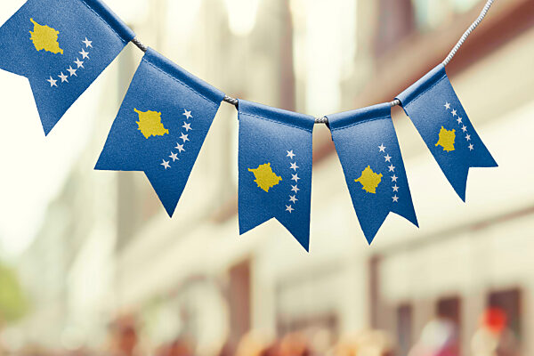 A garland of Kosovo national flags on an abstract blurred background