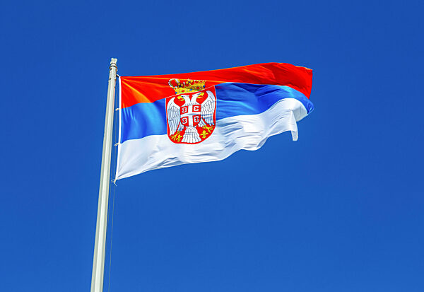 Flag of Serbia flying in the wind against the sky