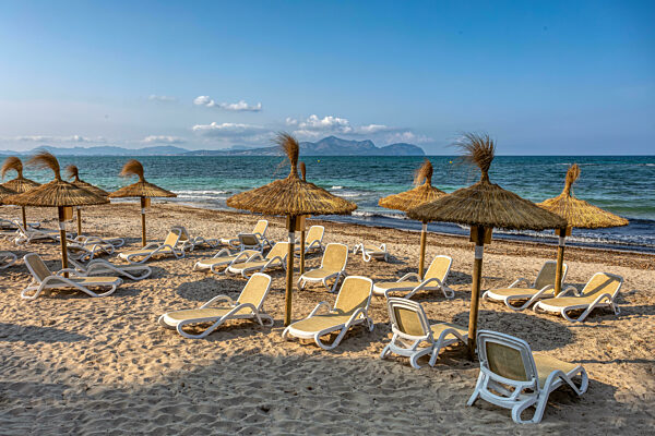Can Picafort Beach with straw umbrellas and sun loungers, Can Picafort, Balearic Islands Mallorca Spain.