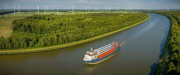 Cargo ship carrying wind turbine blades is navigating through the Kiel Canal.