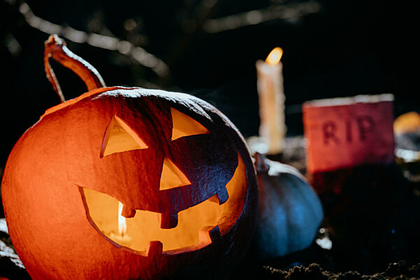 Halloween Jack-o-lantern on ground cemetery at night. Candle light, fog smoke