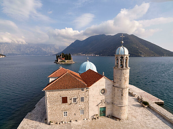 Ancient stone church of Our Lady on the rocks on the island of Gospa od Skrpjela Montenegro. Drone