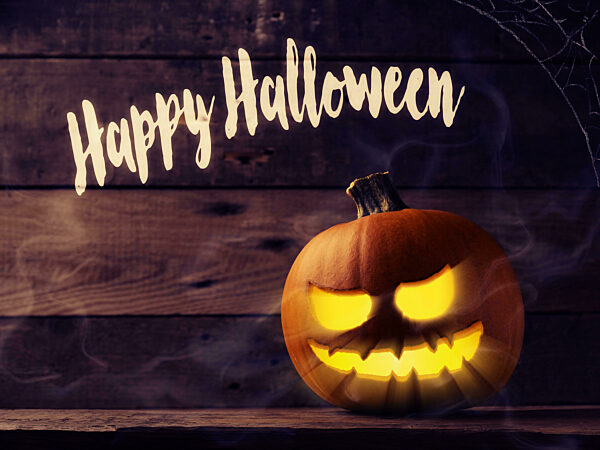 Carved halloween pumpkin Jack o lantner on a rustic wooden table with mist