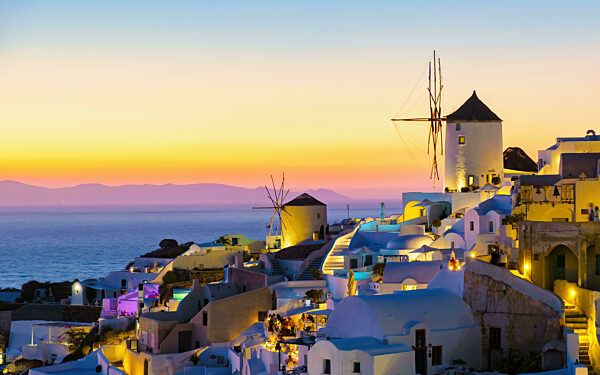 White churches an blue domes by the ocean of Oia Santorini Greece, traditional Greek village