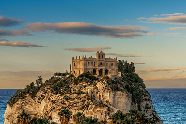 view of the Santa Maria dell'Isola Church on its rocky promontory in Tropea at sunset