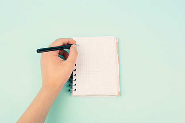 Left handers day, empty notebook, writing with the left hand, pen and table