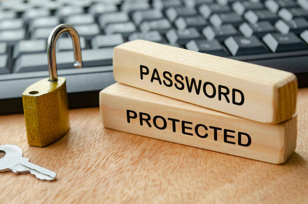 Passwortgeschützter Text auf Holzblöcken mit Vorhängeschloss und Laptop-Tastatur Hintergrund. Passwort-Sicherheitskonzept