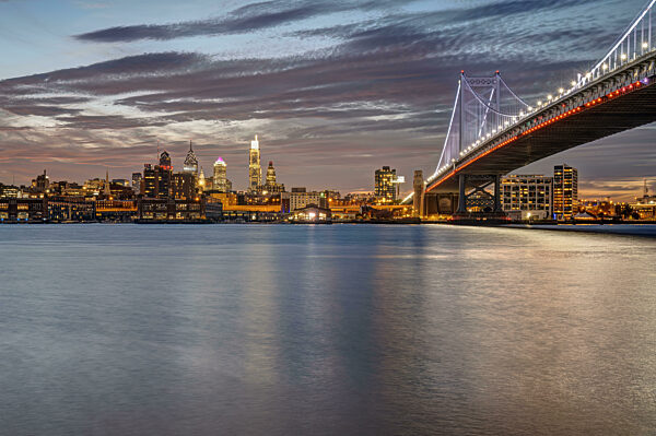 Die Benjamin-Franklin-Brücke und die Skyline von Philadelphia mit dem Delaware River in der Abenddämmerung