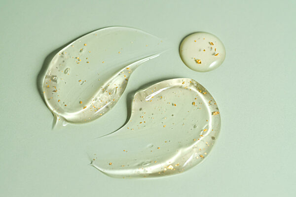 klare 24k Gold Feuchtigkeitscreme Gel Textur Striche isoliert auf grünem Hintergrund. Kosmetische Anti-Aging-Hautpflegeprodukt