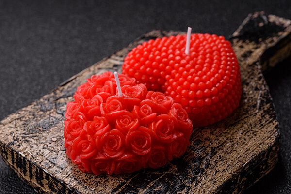 Rote Wachskerze in Form eines Herzens als Dekoration für den Valentinstag