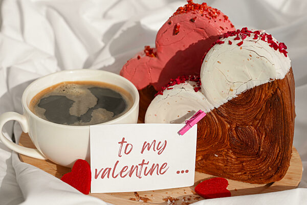 Valentinstag TO MY VALENTINE Wünsche Spruch auf Grußkarte Kaffeefrühstück in zerwühltem Bettzeug Bett mit herzförmigen Gebäck Croissant behandeln. Lebensmittel Experimentieren virale Dessert Backen Trend